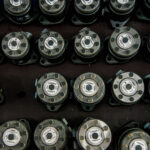 Mehrere identische Hydraulikmotoren liegen in sauberer Anordnung nebeneinander, die Gehäusedeckel zeigen Typenschilder und Schraubverbindungen.